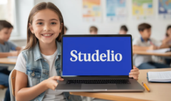 Une collégienne souriante et pleine de vie montre son ordinateur où est inscrit "Studelio" en blanc sur un fond bleu vif (#3261c5). Elle semble enthousiaste, incarnant l'esprit d'apprentissage et de partage des connaissances en français.