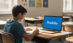 L'image montre un élève concentré devant son ordinateur, où le mot "Studelio" est affiché en blanc sur un fond bleu vif. Cet élève participe à un exercice de dictée, s'entraînant à l'écriture et à l'orthographe, une méthode essentielle pour améliorer ses compétences en langue française.
